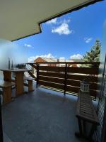 a balcony with a table and a bench on it at Studio cosy et moderne aux pieds des pistes in LʼHuez