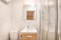 a white bathroom with a sink and a shower at Le nid de la Corderie in Marseille