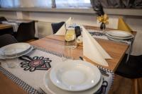 a table with white plates on a wooden table at WRZOS resort & wellness in Węgierska Górka