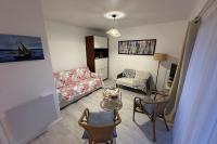 a living room with a couch and a table and chairs at Studio with balcony - 2 min beach and AquaBaule in La Baule