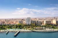 a city with a body of water and buildings at NYX Hotel Limassol in Limassol