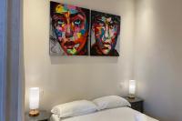 a bedroom with two paintings of faces on the wall at Apartment Matisse 100Mt Near The Sea - Happy Rentals in Antibes
