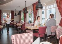 un grupo de personas en un restaurante con mesas y sillas en Hotel Hessenhof, en Winterberg