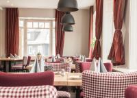 Un restaurante con mesas y sillas y una ventana. en Hotel Hessenhof, en Winterberg