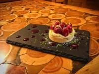 アルヴィユーにあるLe Chalet des Sommetsのテーブルの上の黒板の上にベリーの入ったペストリー