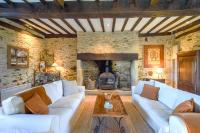 a living room with two white couches and a fireplace at Domaine d&#39;Essendiéras in Saint-Médard-dʼExcideuil