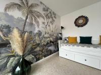 a bedroom with a palm tree mural on the wall at Cocon front de mer côté cour in Lacanau