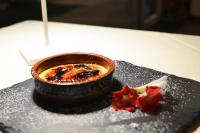 une assiette noire avec un bol de nourriture sur une table dans l'établissement Relais Villa Olivi, à Costermano