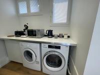 a kitchen with a washing machine and a microwave at Douce brise à Seignosse-2 min à pied de la plage in Seignosse