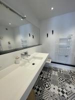 a white bathroom with a sink and a mirror at Douce brise à Seignosse-2 min à pied de la plage in Seignosse