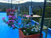Un balcón con mesas y sillas y flores. en Santa Lucia Estancia Rural, en Guaduas
