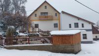 a house with a fence in the snow at Chalupa a apartmány Marika in Cerny Dul