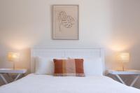 a bedroom with a white bed with two lamps at Basedow Units Tanunda in Tanunda