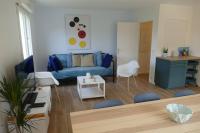 a living room with a blue couch and a table at Disneyland Paris, appartement 70m², parking privé in Serris