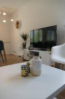 a living room with a tv and a white table at Disneyland Paris, appartement 70m², parking privé in Serris