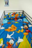 a bed with mickey mouse and goofy on it at Disneyland Paris, appartement 70m², parking privé in Serris