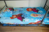 a futon bed with a blanket with disney characters on it at Disneyland Paris, appartement 70m², parking privé in Serris