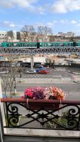 a train on a bridge over a parking lot with flowers at Austerlitz Cocoon in Paris