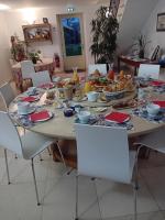 a table with food on it with white chairs at Domaine de kerbillec in Theix