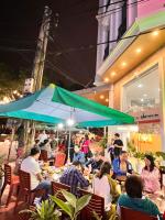 een groep mensen die aan een tafel zitten onder een paraplu bij KEZAN Hotel in Hòa Ðình