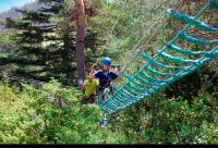 two people on a zip line in the trees at Au petit paradis in Camiers