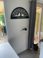 a black cat standing next to a door with a welcome sign at Au petit paradis in Camiers