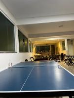 a ping pong table in a room with tables and chairs at Pousada Portico de Buzios in Armacao dos Buzios