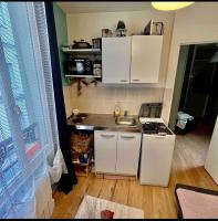 a small kitchen with white cabinets and a sink at Private room in Paris