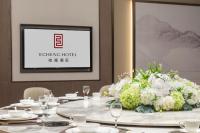 a dining room with a table with a flower centerpiece at Echeng Hotel - Huawei Base Store in Shenzhen in Shenzhen