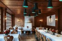 Hotel Goldene Sonne في لاندشوت: مطعم بطاولات بيضاء وكراسي واضاءات زرقاء