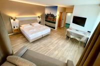 a bedroom with a bed and a desk and a television at Hotel &amp; Restaurant Bergfried in Saalfeld