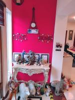 a pink wall with stuffed animals and a table with a clock at White Palace B&amp;B in Ji&#39;an