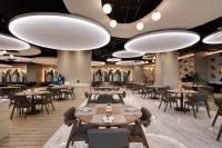 a restaurant with tables and chairs and large lights at St Giles Southkey in Johor Bahru