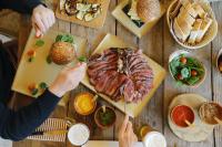 een tafel met daarop een bord met vlees en eten bij Asolo Norah's Hill Agri Rooms in Caenere