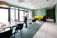 a person standing in a restaurant with tables and chairs at Campanile Limoges Centre - Gare in Limoges