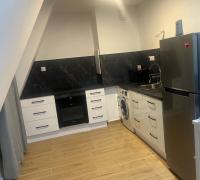 a kitchen with a refrigerator and a dishwasher at Parisian Skyline Oasis: Panoramic Elegance, Luxury at Your Doorstep in Saint-Ouen
