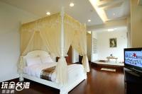 a bedroom with a canopy bed and a television at Ti Siang B&amp;B in Ren&#39;ai