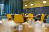 Un comedor con mesas y sillas amarillas. en HOTEL JAVIER MONTERO, en Ribadeo