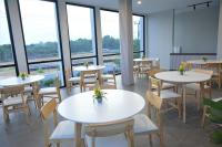 a restaurant with white tables and chairs and windows at ONYX HOTEL & VILLA in Tanjunguban