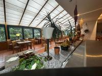 a restaurant with tables and chairs and a glass ceiling at Landhotel Harz in Thale