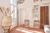 a room with two chairs and a table and a vase at |Aaa|- Pure &amp; Natural Massilia City Center in Marseille