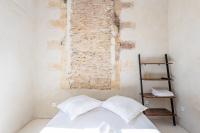 a bedroom with a white bed and a brick wall at |Aaa|- Pure &amp; Natural Massilia City Center in Marseille