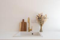 a kitchen sink with a vase of flowers next to it at |Aaa|- Pure &amp; Natural Massilia City Center in Marseille