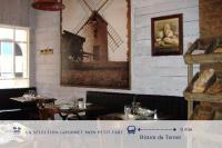 a restaurant with a picture of a windmill on the wall at La Compiègnoise - Spacieux - Lumineux - Cosy in Compiègne