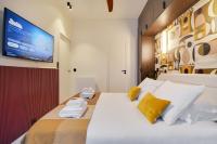 a bedroom with a white bed with a tv on the wall at CMG - La Butte Montmartre in Paris