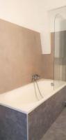 a bath tub with a shower in a bathroom at Cocon Rue Ecuyère - Calme- 2ch - 6pers in Caen