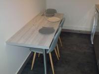 - une table avec 4 chaises et des verres à vin dans l&#39;établissement Appart Limoges centre gare., à Limoges