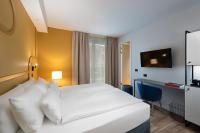 A bed or beds in a room at HT Hotel Trieste
