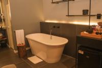 a bath tub in a bathroom with a sink at Jangal das Araucárias Swan Design Hotel Canela in Canela