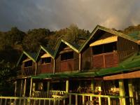 una gran casa de madera con una montaña en el fondo en Liberty's Lodge and Diving - Apo Island, en Dumaguete